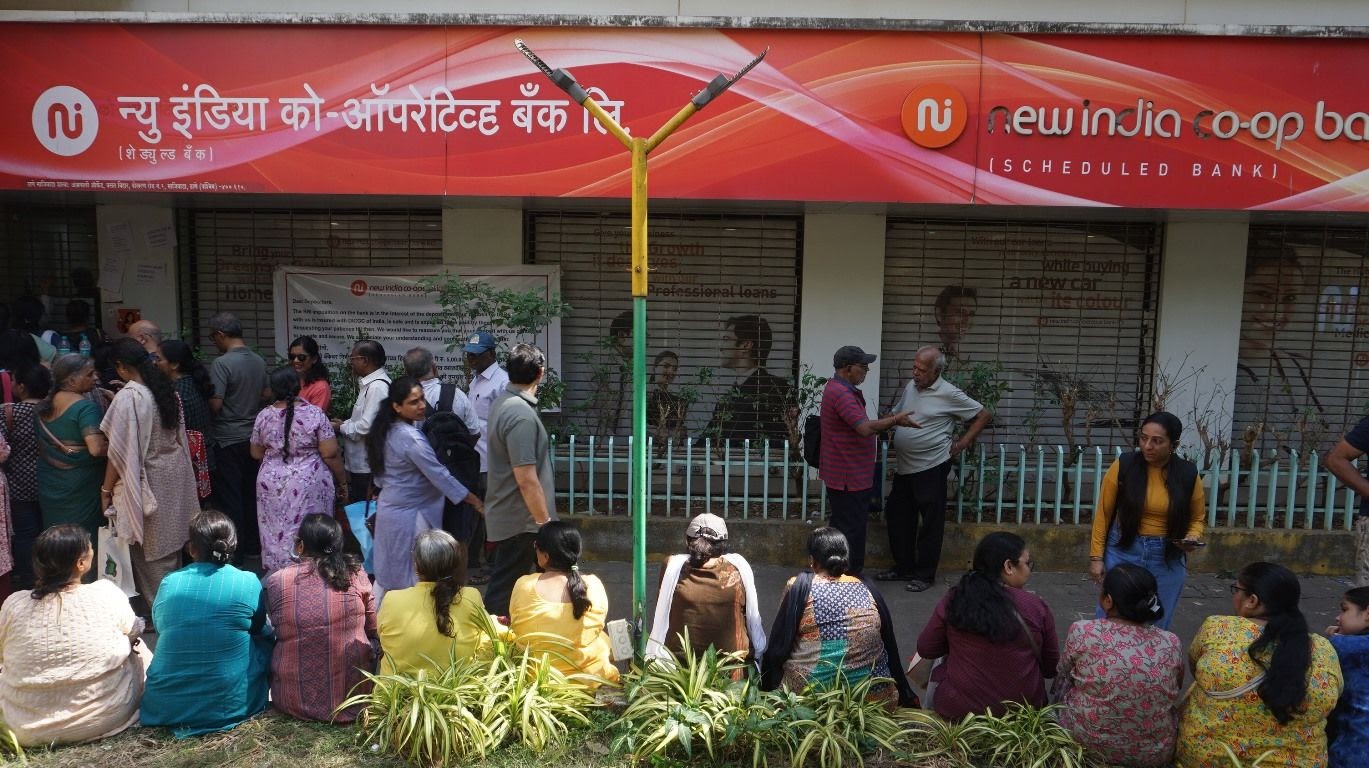 Everyday Indian depositors standing outside a local rural co-operative bank branch, representing the citizens protected by the new RBI governance rules.